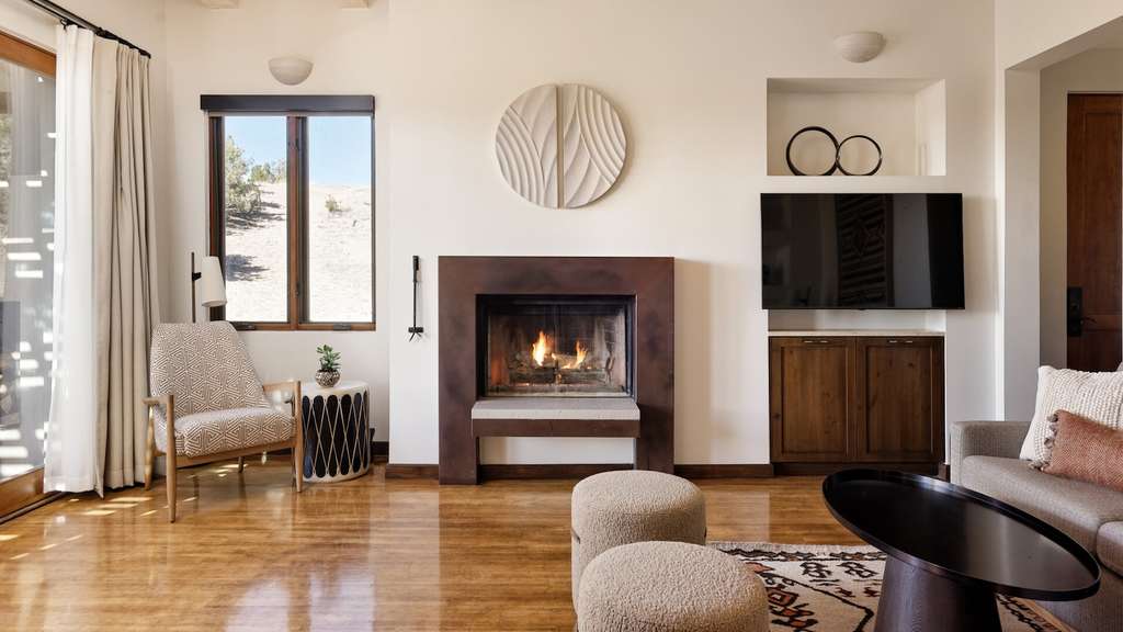 A fireplace in the centre of a living space, with seating options.