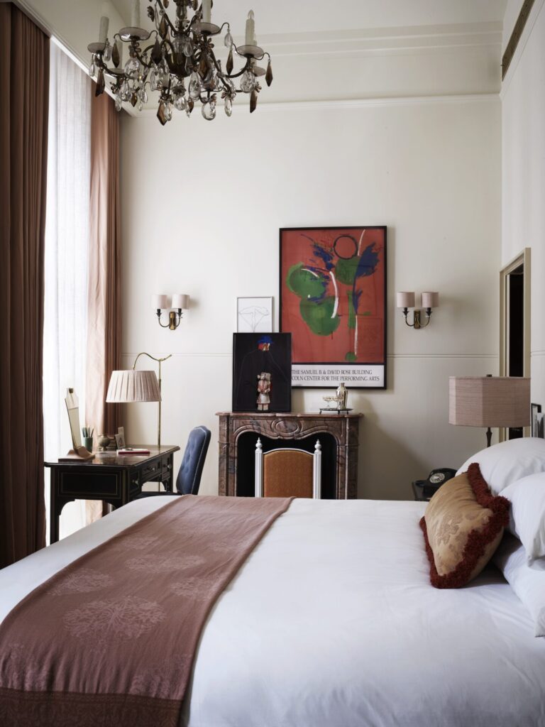 A large bed with a desk at a corner, and local art hung up on the walls.