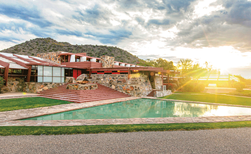 A pool in the foreground and the resort in the back.