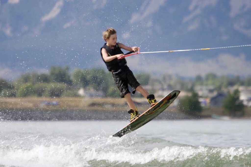 A kid enjoys a watersport. 