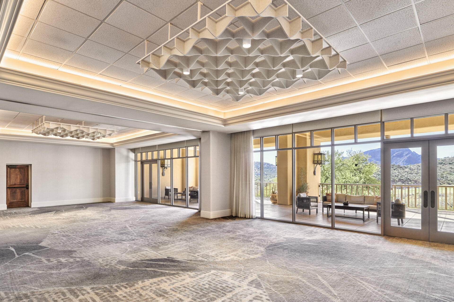 A boardroom with white chairs against a window looking out to the desert.