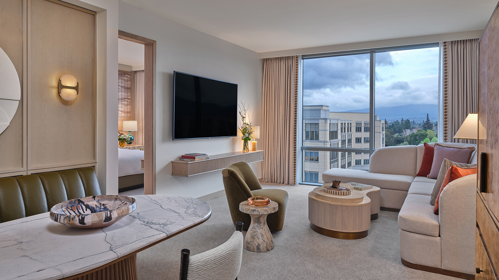 A Four Seasons hotel suite with a banquette dining area and a seating area.