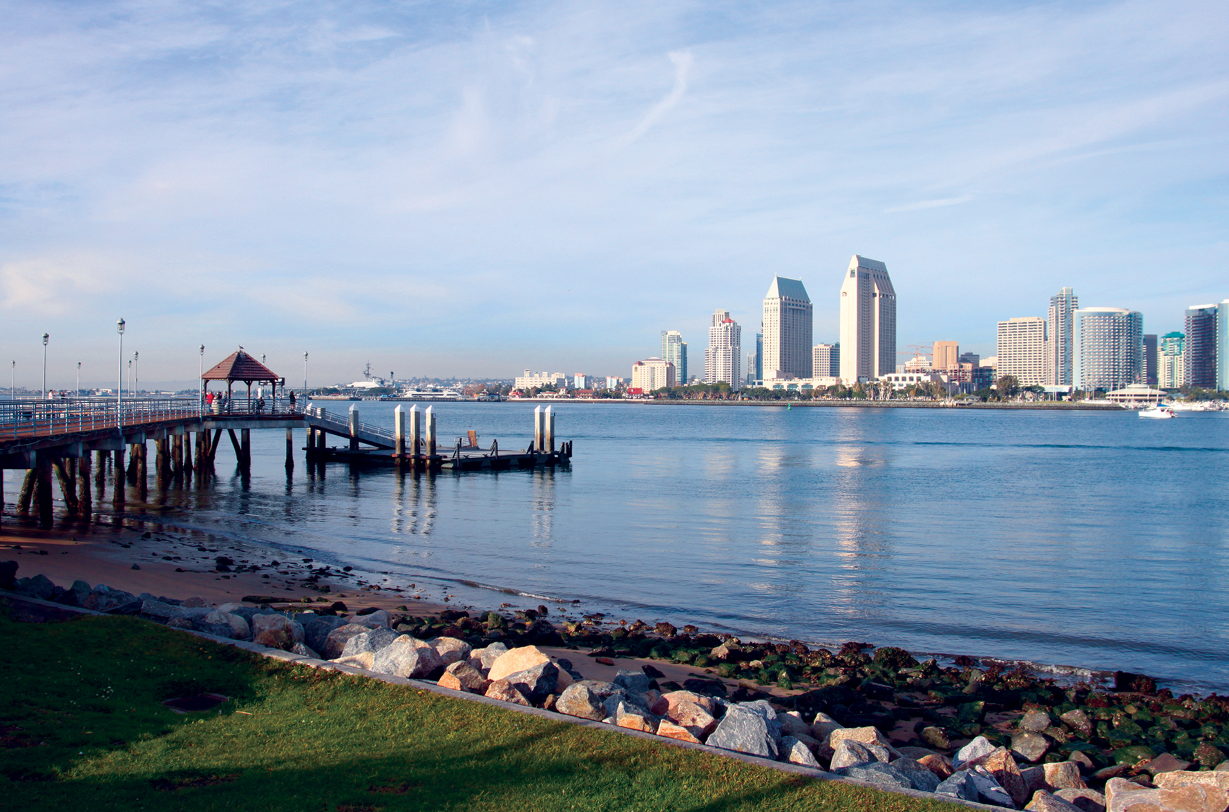 View of downtown San Diego across San Diego Bay, with a waterfront pier in the foreground.