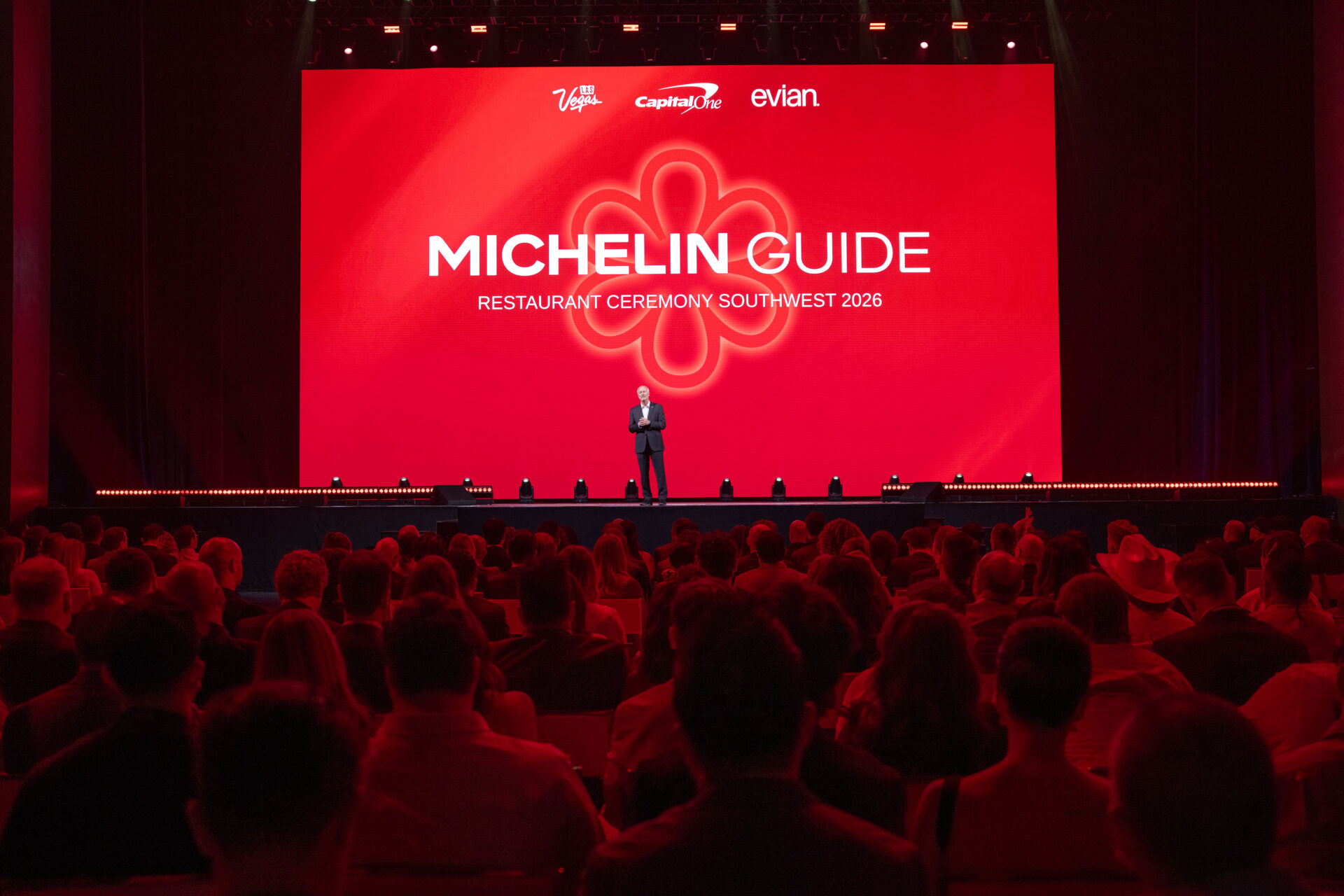 A speaker stands onstage at the inaugural MICHELIN Guide Southwest 2026 restaurant ceremony in Las Vegas, with a large red MICHELIN Guide backdrop and a seated audience in the foreground.